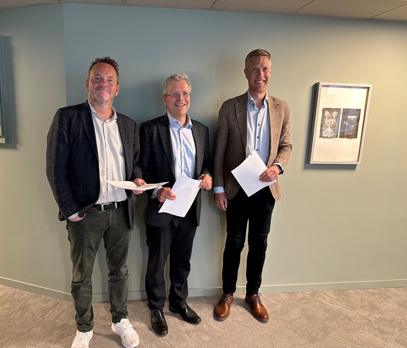 Three men pose for a photo during pay negotiations