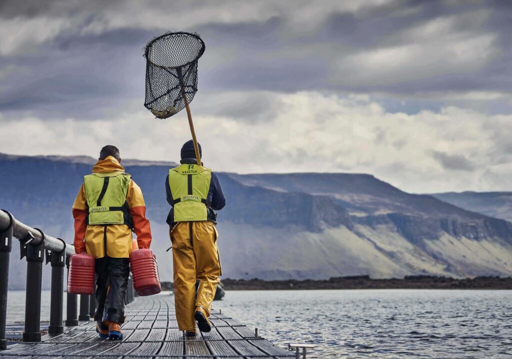 two men in life jackets with fish net