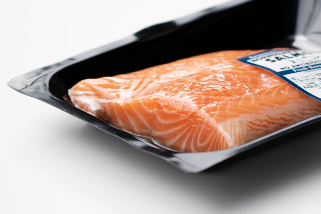 Closeup of fresh farmed Atlantic salmon fillet in orange color with clear white veins in a vacuum sealed plastic container isolated on a white background. Licensed Find Similar File #: 485482580 Closeup of fresh farmed Atlantic salmon fillet in orange color with clear white veins in a vacuum sealed plastic container isolated on a white background