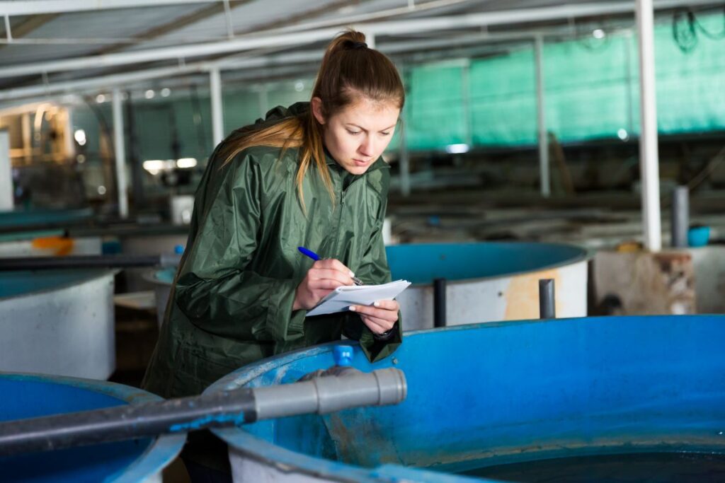 Woman looking into fish farm tank