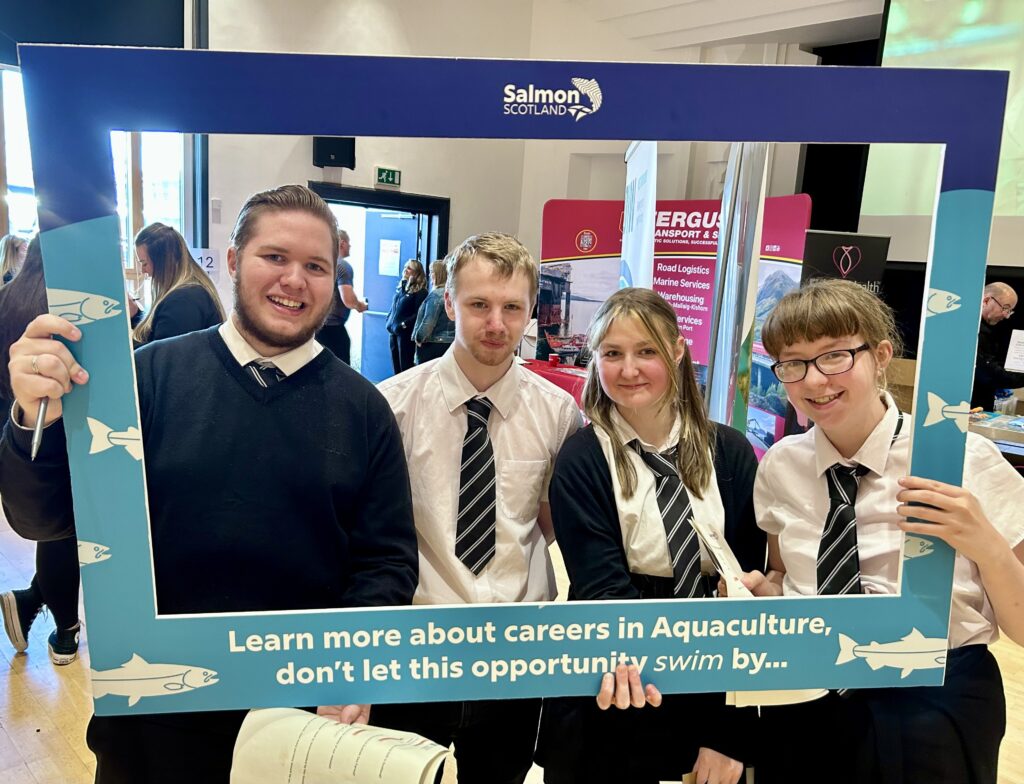 Young people pose with a selfie frame